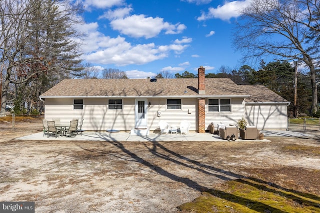 back of property with a shingled roof, a chimney, a patio area, and central air condition unit