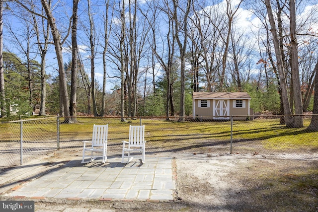 view of yard featuring an outbuilding, a patio area, a storage unit, and fence private yard