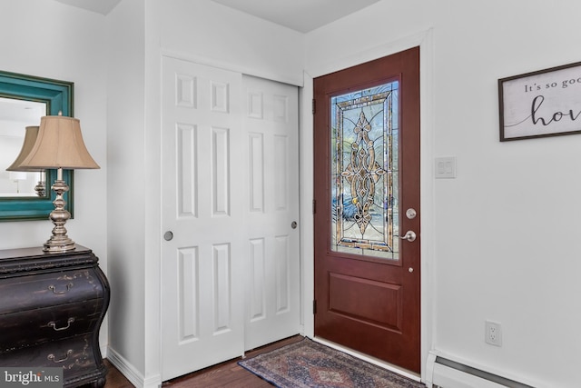 entrance foyer featuring baseboards, baseboard heating, and wood finished floors