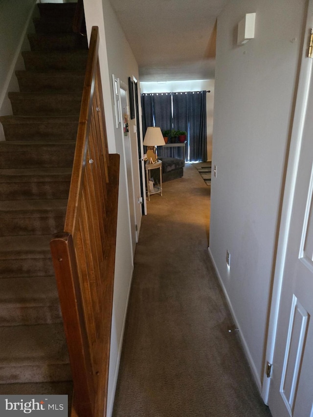 hall with carpet floors, stairs, and baseboards