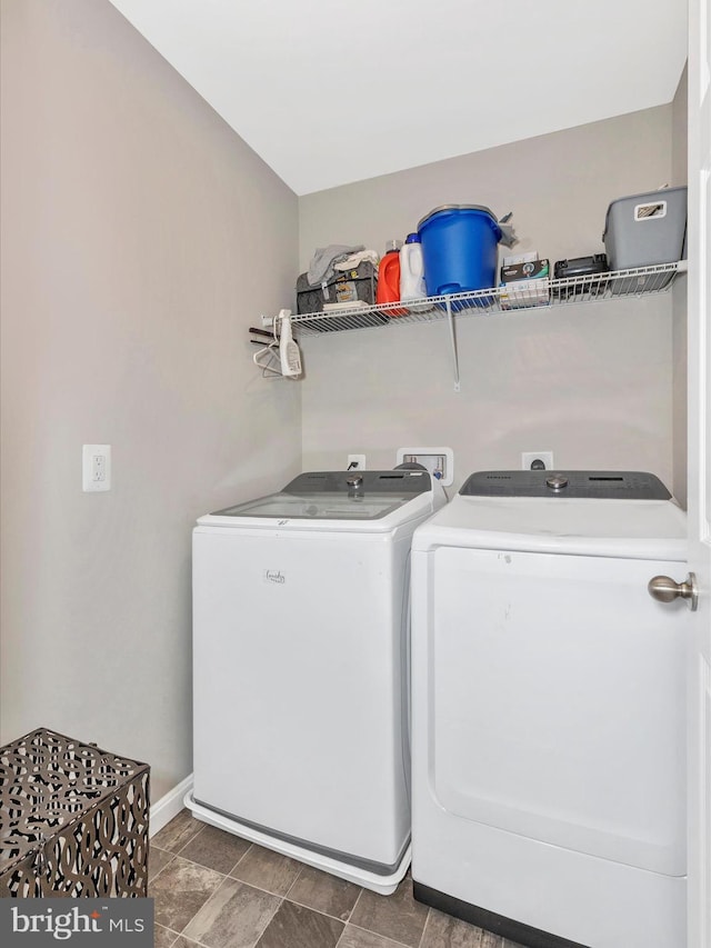 washroom featuring laundry area, washing machine and dryer, and baseboards