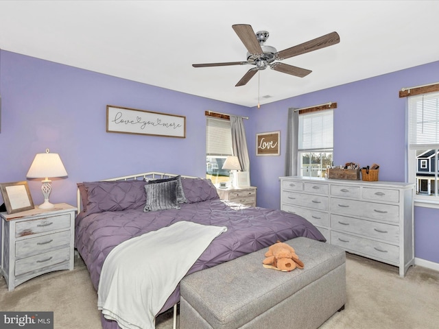 bedroom with light carpet, a ceiling fan, and baseboards