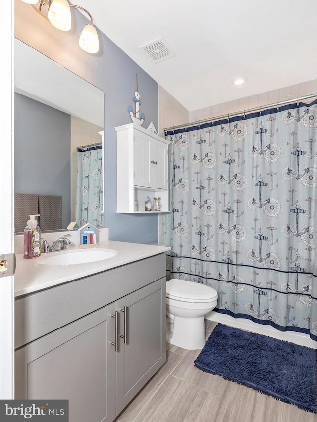 full bathroom with toilet, a shower with curtain, visible vents, and vanity