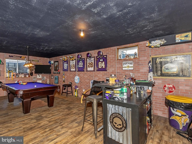 game room with brick wall, wood finished floors, and billiards