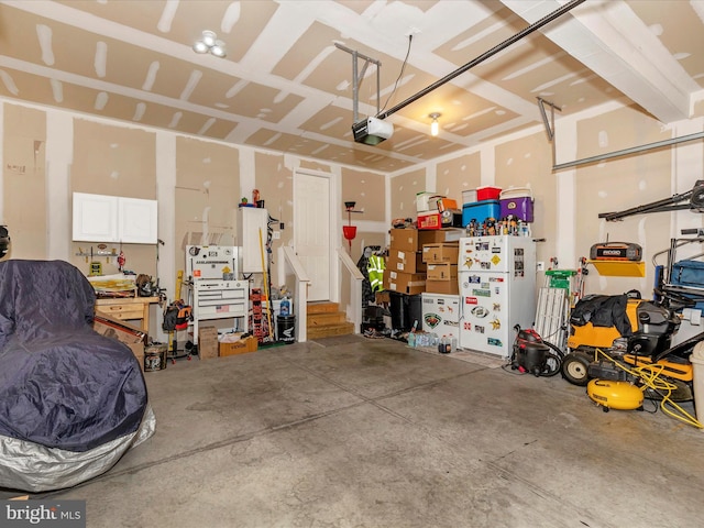 garage with a workshop area and a garage door opener