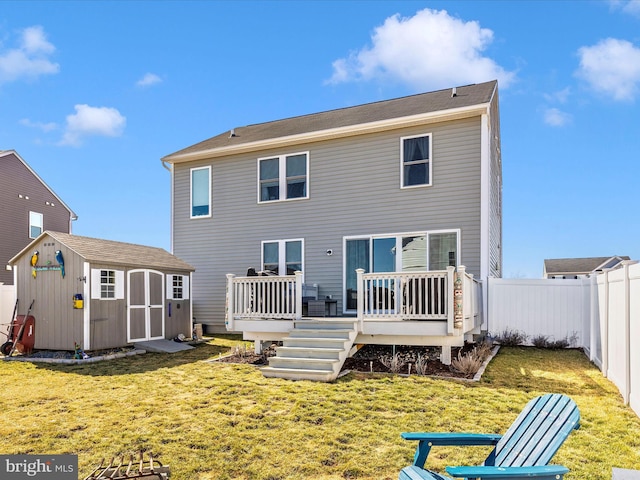 back of house with an outbuilding, a fenced backyard, a yard, a wooden deck, and a shed