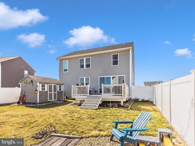 back of house featuring a fenced backyard, an outdoor structure, a lawn, a wooden deck, and a storage unit