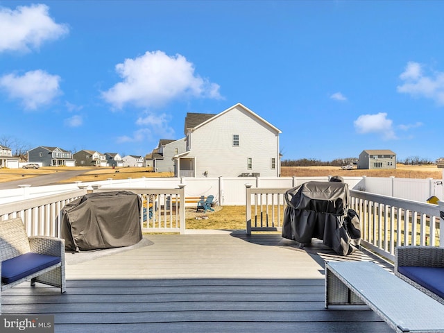 wooden deck featuring a fenced backyard, a residential view, and grilling area