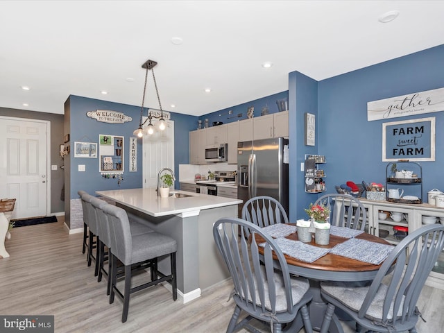 dining area with recessed lighting, baseboards, and light wood finished floors