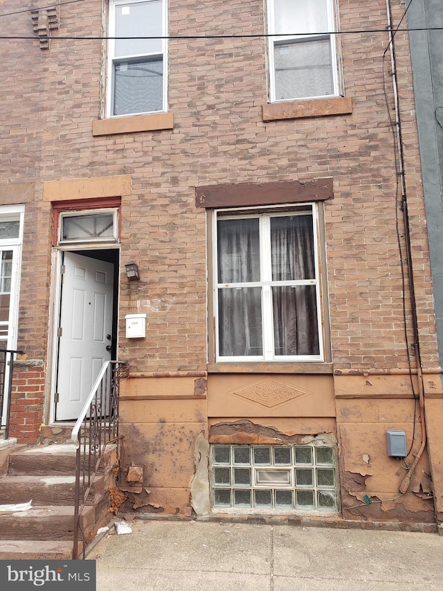 entrance to property featuring brick siding