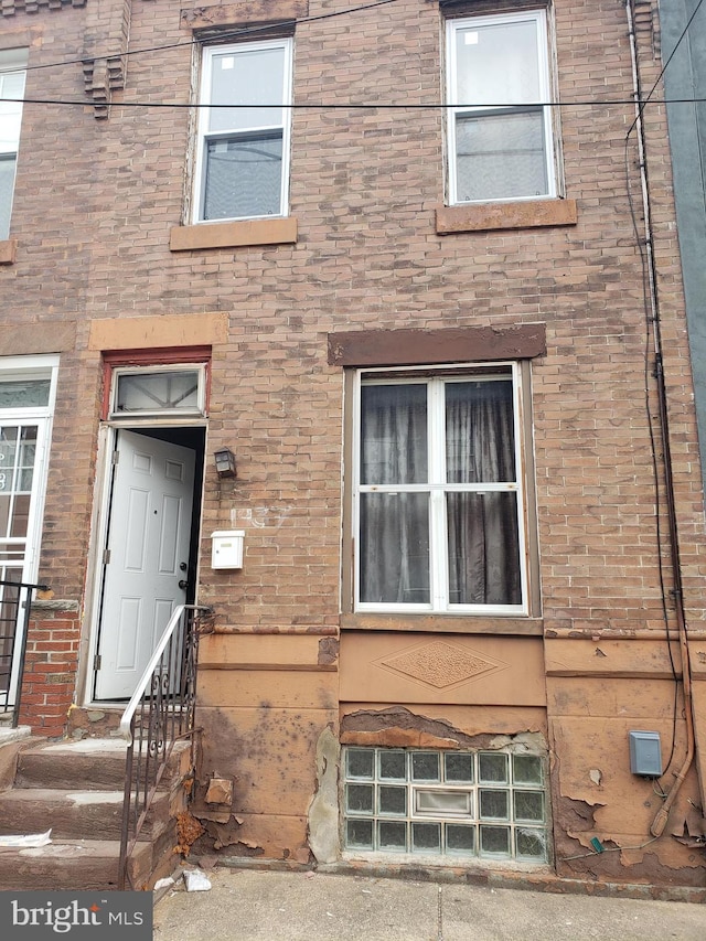 doorway to property featuring brick siding