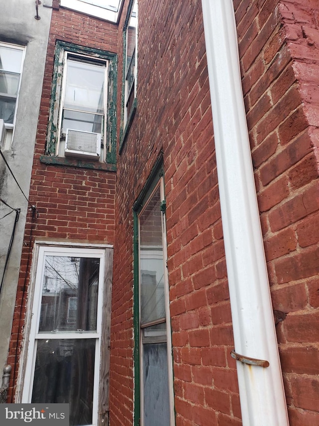 view of home's exterior with cooling unit and brick siding