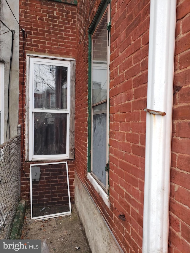 entrance to property featuring brick siding