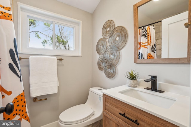 bathroom featuring curtained shower, toilet, and vanity