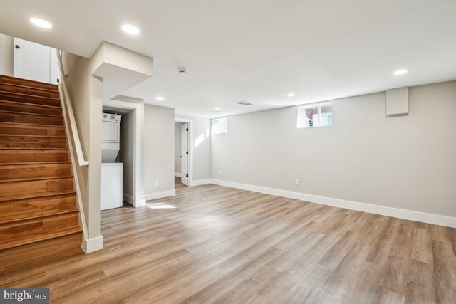 below grade area featuring recessed lighting, baseboards, light wood-style floors, and stacked washer / dryer