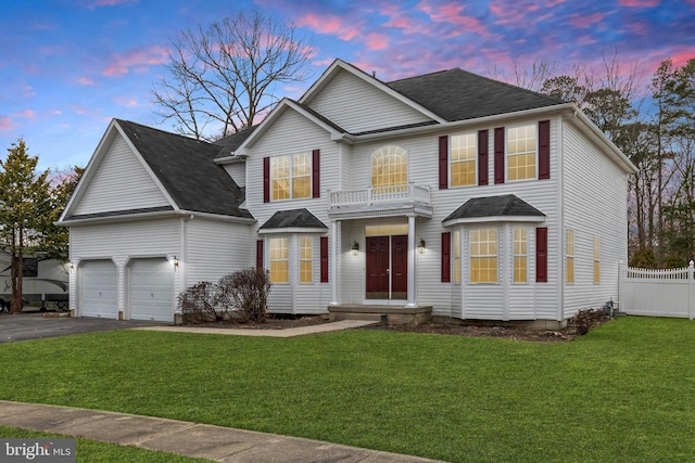 view of front of home featuring a yard, fence, a balcony, a garage, and driveway