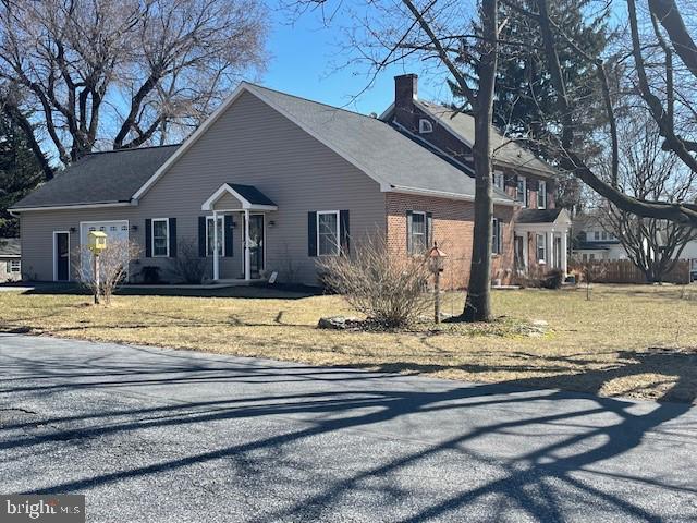 view of side of property featuring a lawn and brick siding