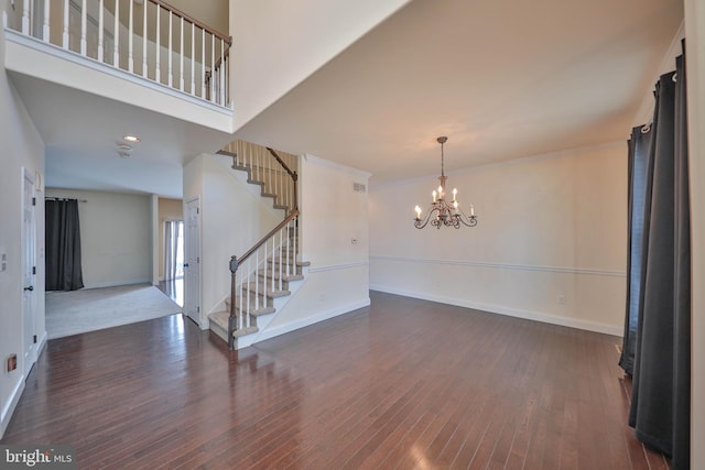 interior space with an inviting chandelier, stairs, baseboards, and wood finished floors