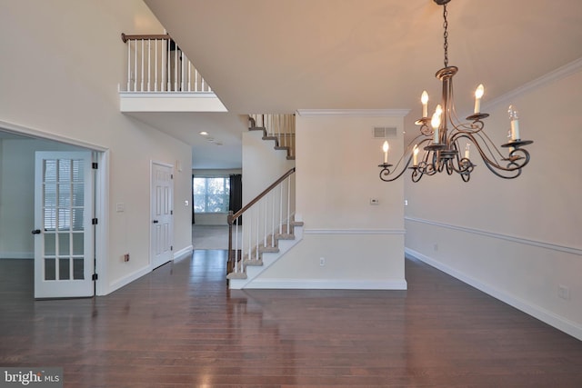 entrance foyer with visible vents, an inviting chandelier, wood finished floors, baseboards, and stairs