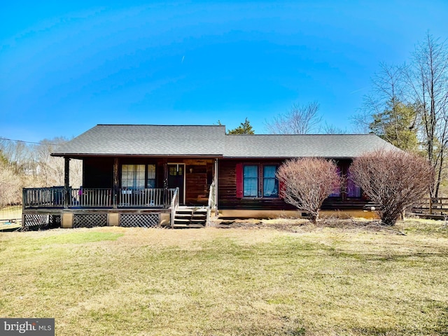 view of front of property featuring a front lawn, covered porch, and a shingled roof