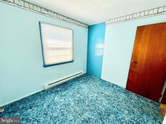 empty room featuring a baseboard radiator, carpet floors, and baseboards