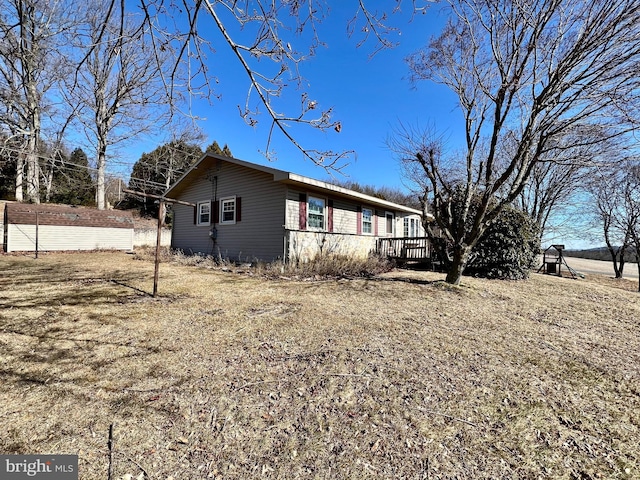 view of property exterior with an outbuilding and a wooden deck