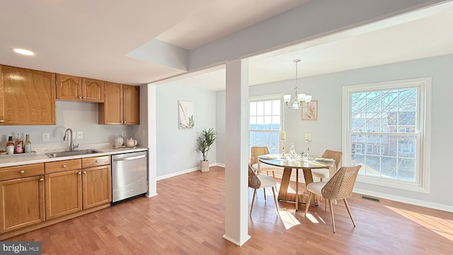 kitchen featuring light wood finished floors, visible vents, dishwasher, light countertops, and a sink