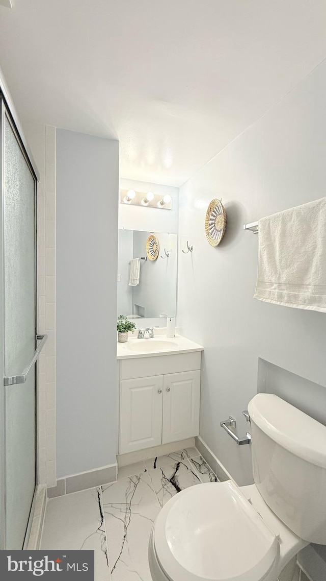 full bath featuring toilet, marble finish floor, vanity, and a stall shower