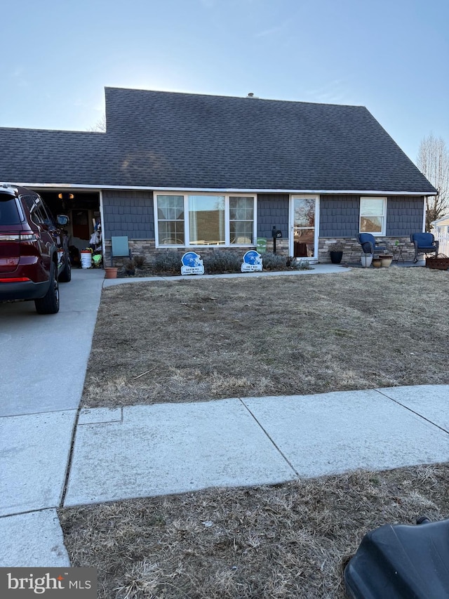 view of front facade with roof with shingles and concrete driveway