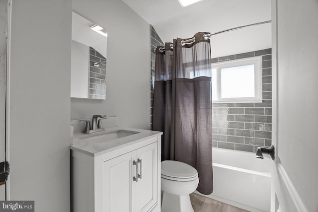 bathroom with wood finished floors, toilet, vanity, and shower / bath combo