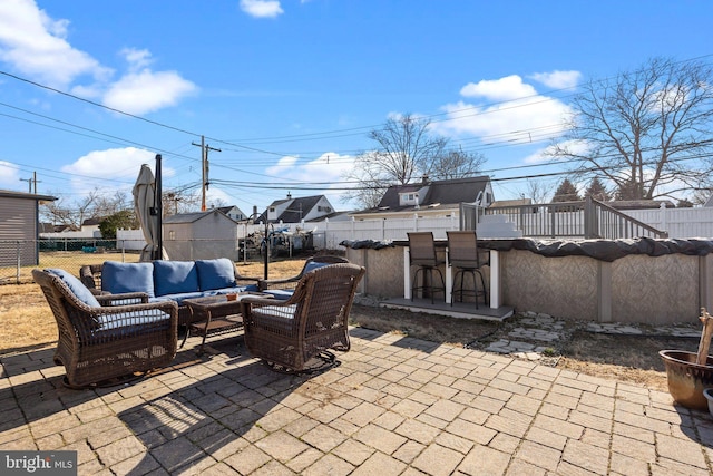 view of patio / terrace featuring an outdoor living space, a fenced backyard, and outdoor dry bar