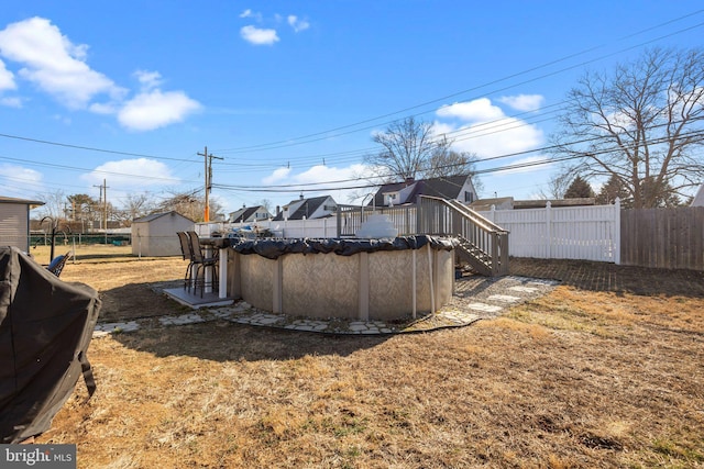 view of yard with a fenced in pool, an outbuilding, a storage shed, and fence