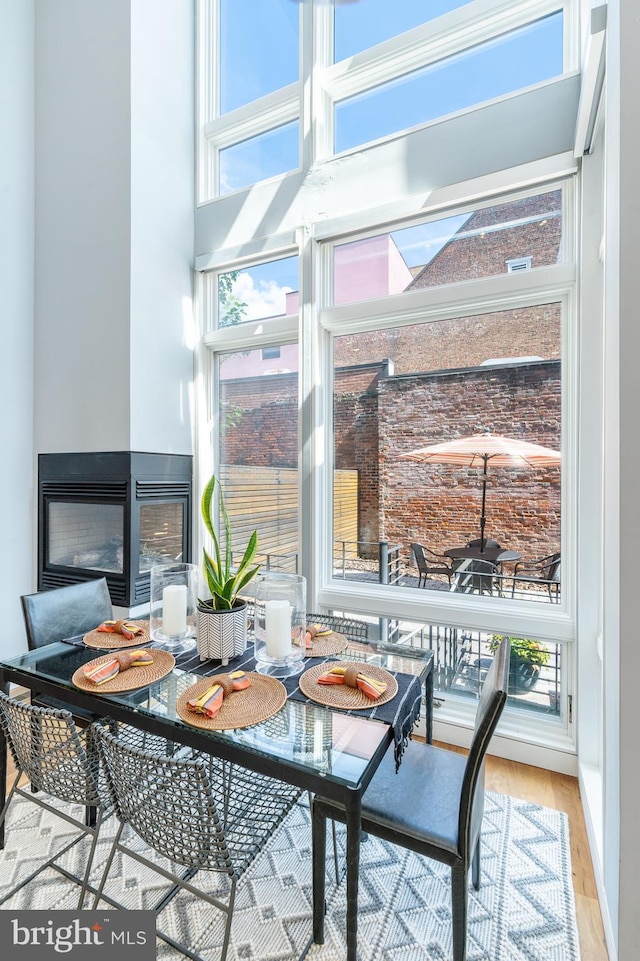 sunroom / solarium featuring a healthy amount of sunlight and a multi sided fireplace