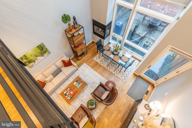 living room featuring wood finished floors and a multi sided fireplace