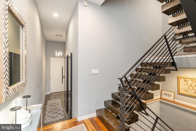 stairs with wood finished floors and baseboards