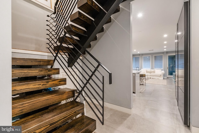 stairway featuring baseboards and recessed lighting