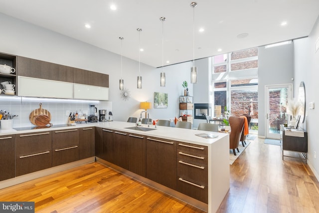 kitchen featuring light countertops, a sink, a peninsula, and modern cabinets