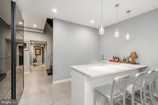 bar with pendant lighting, recessed lighting, a bar, baseboards, and stairs