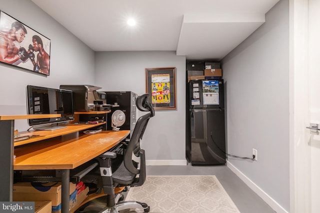 office space with concrete floors and baseboards