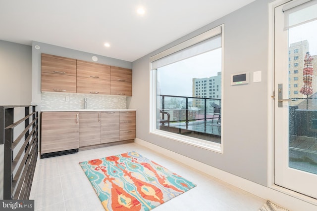 interior space with light tile patterned floors, recessed lighting, baseboards, light countertops, and decorative backsplash