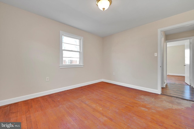 unfurnished room featuring baseboards and hardwood / wood-style flooring