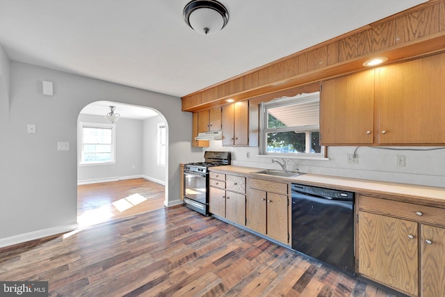 kitchen featuring arched walkways, black dishwasher, gas stove, a sink, and under cabinet range hood