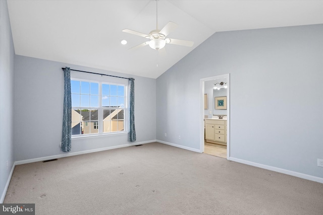 unfurnished bedroom with visible vents, baseboards, light carpet, lofted ceiling, and ensuite bath