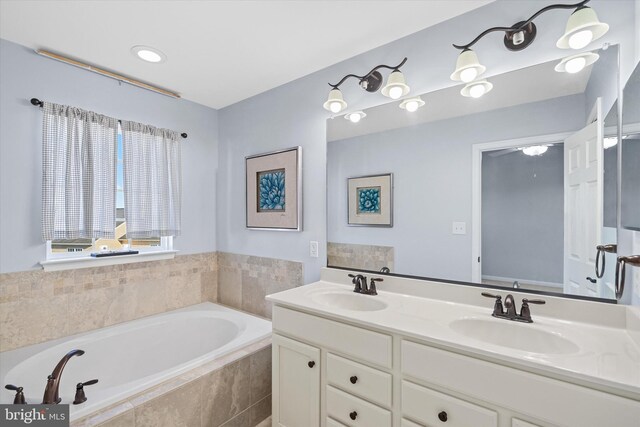 bathroom with double vanity, a sink, and a garden tub