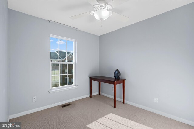 unfurnished room with baseboards, carpet flooring, visible vents, and a ceiling fan