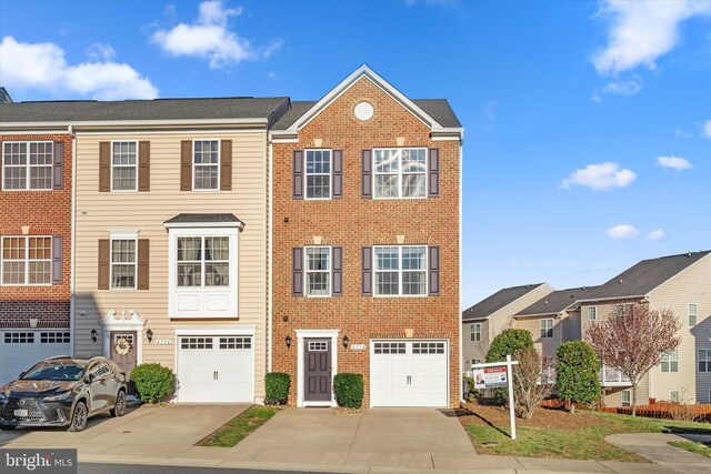 multi unit property featuring driveway, brick siding, and a garage