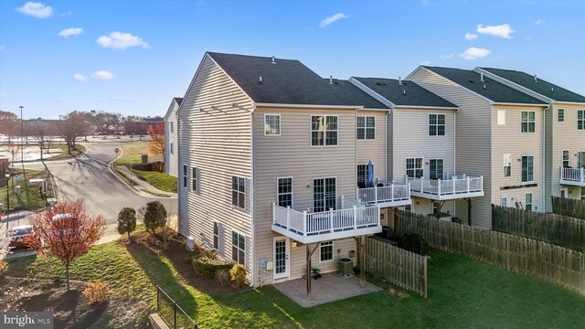 rear view of property featuring cooling unit, fence, a yard, and a patio