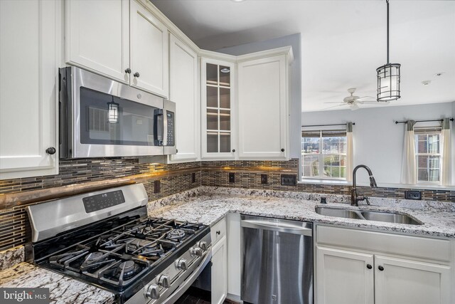 kitchen with a wealth of natural light, tasteful backsplash, a sink, and stainless steel appliances