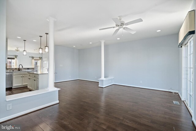 unfurnished living room featuring dark wood-style floors, decorative columns, recessed lighting, and a ceiling fan