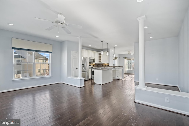 living room featuring decorative columns, dark wood-style flooring, recessed lighting, and a ceiling fan